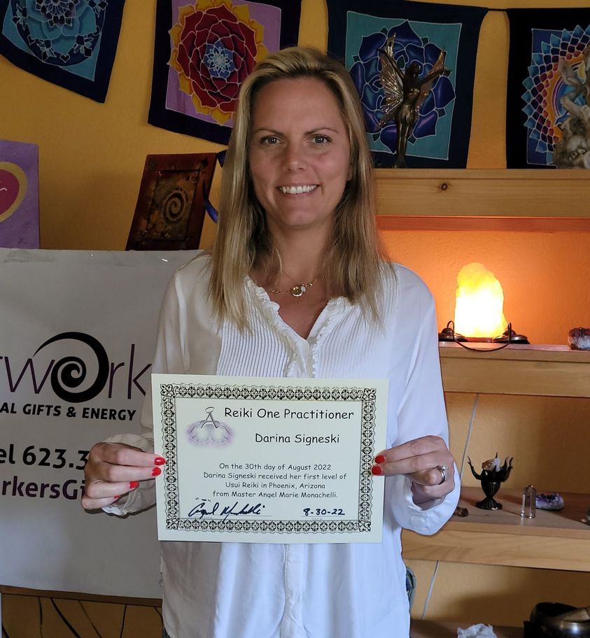 A Reiki One Practitioner graduate holding her certificate, signed by Master Angel Marie Monachelli