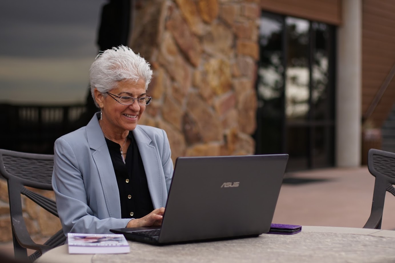 Angel Marie Monachelli working outdoors on her laptop